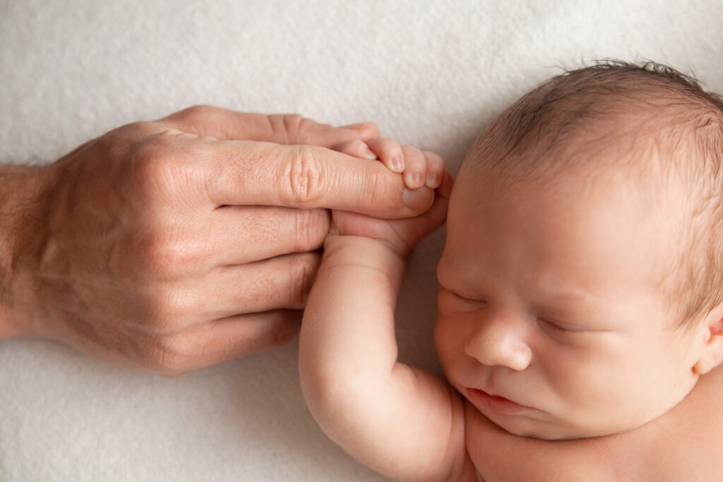 newborn baby boy holding moms hand in claremore newborn session