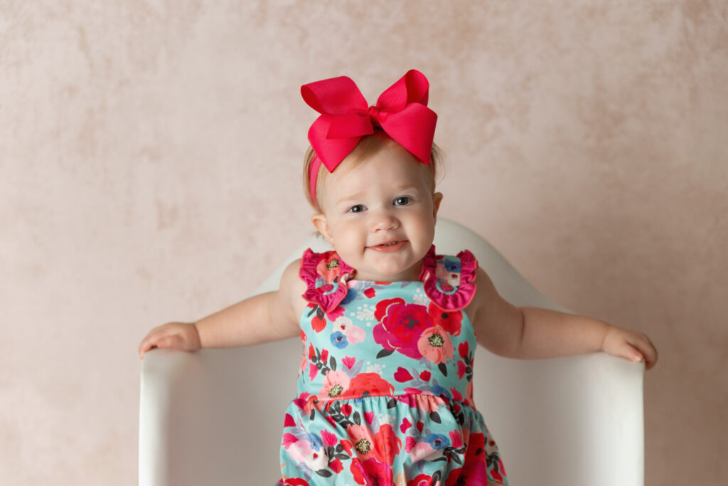 little girl with pink background in Clarmore newborn photography studio