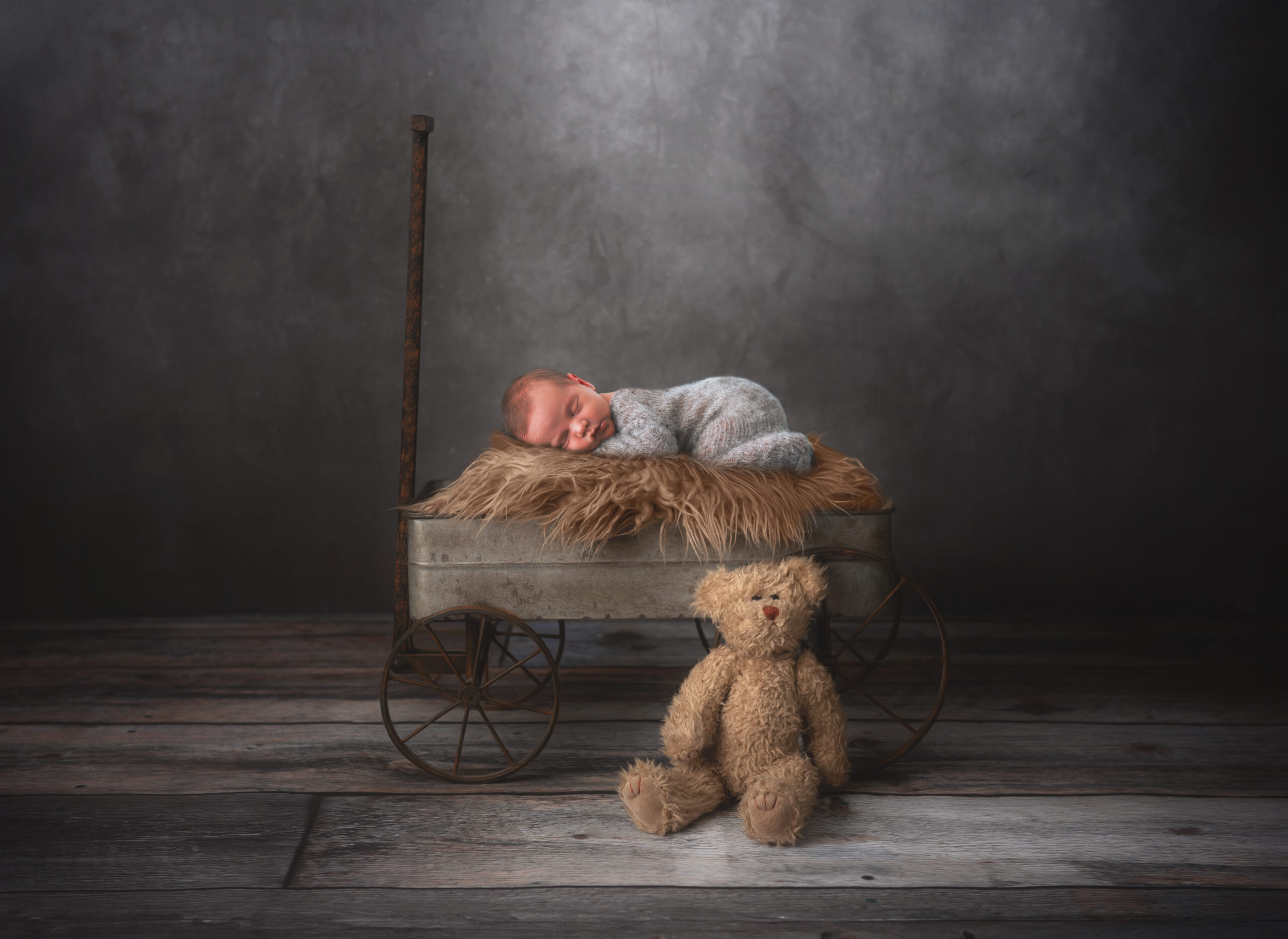 baby boy on wagon with teddy bear in Claremore newborn photography studio 