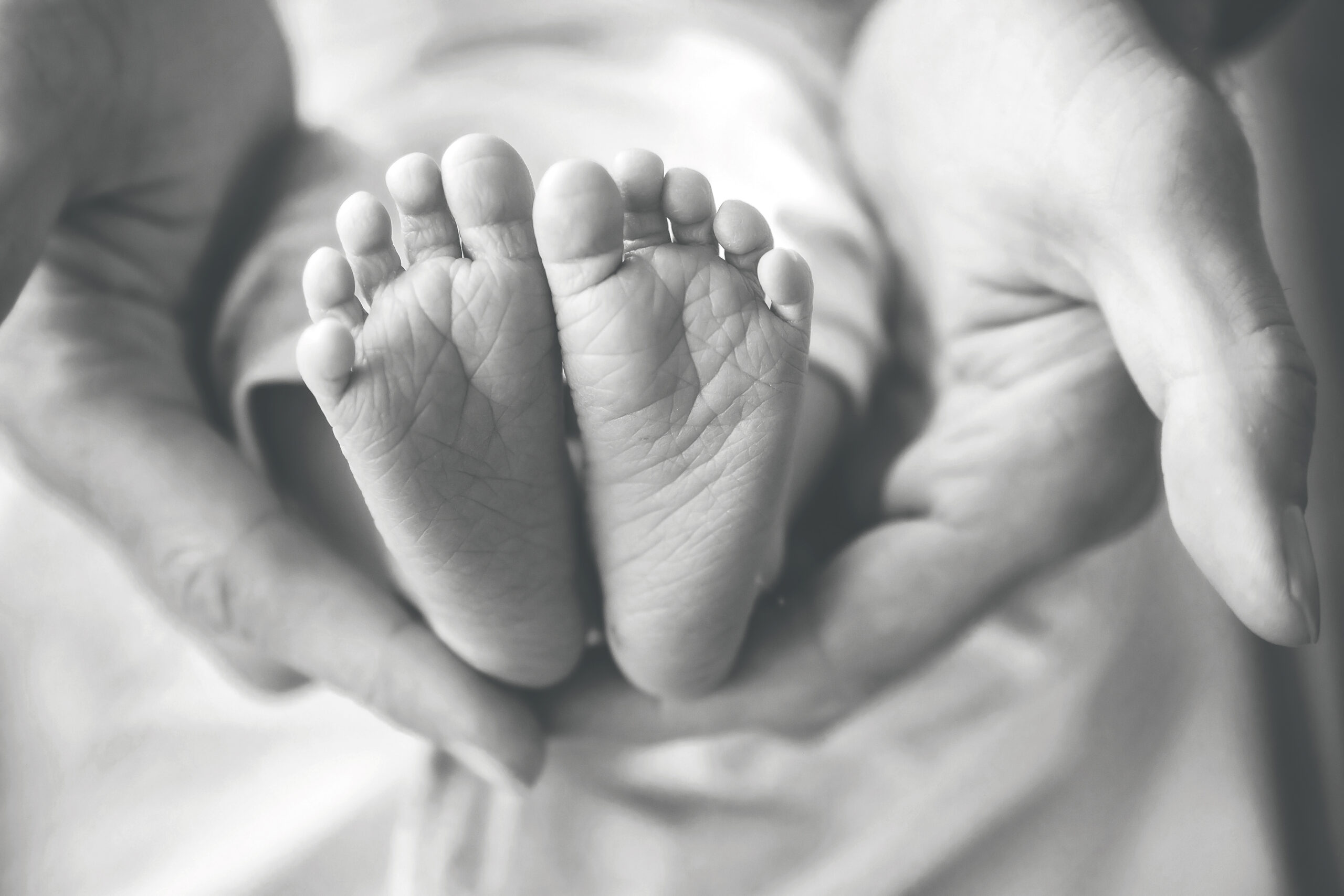 dad holding newborn baby's feet in his hands